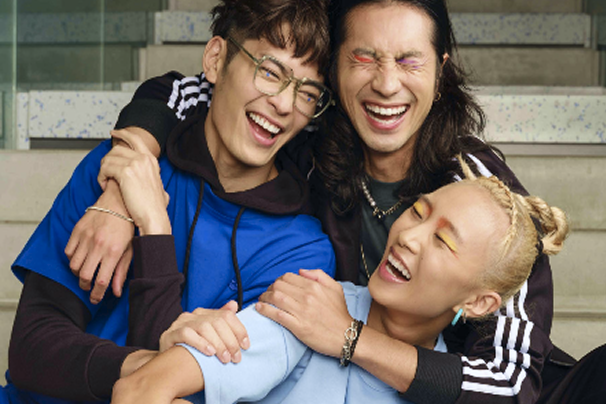 Three people laughing and hugging each other